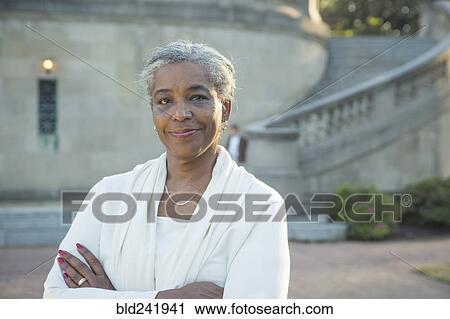 Stock Image - Portrait of Black woman posing near stone staircase. Fotosearch