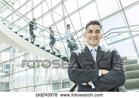 Stock Photo - Portrait of businessman standing near staircase. Fotosearch