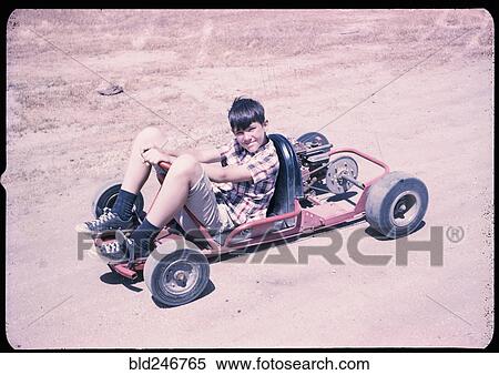 Stock Photography - Portrait of Caucasian boy sitting on go-cart. Fotosearch