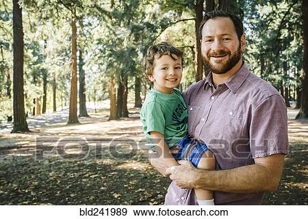Stock Photo - Portrait of Caucasian father carrying son. Fotosearch