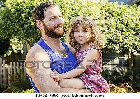 Stock Photograph - Portrait of Caucasian father carrying daughter. Fotosearch