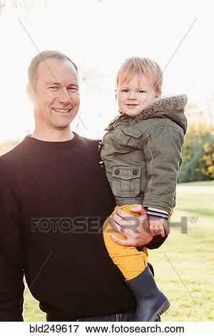 Stock Photo - Portrait of Caucasian father posing with son. Fotosearch