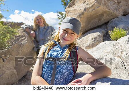 Stock Image - Portrait of Caucasian girl and grandmother hiking near rocks. Fotosearch