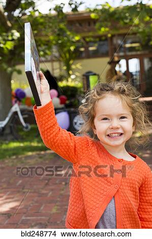 Picture - Portrait of Caucasian girl holding DVD movie. Fotosearch