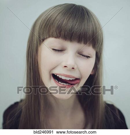 Stock Image - Portrait of Caucasian girl licking lips. Fotosearch