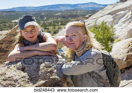 Stock Image - Portrait of Caucasian grandmother and granddaughter leaning on rock. Fotosearch