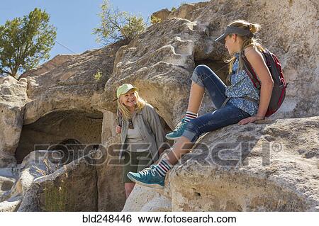 Stock Photograph - Portrait of Caucasian grandmother and granddaughter playing on rock. Fotosearch