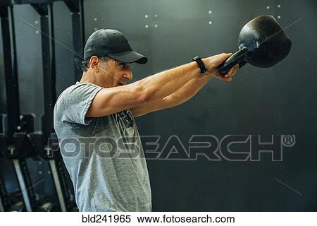 Portrait of Caucasian man lifting kettlebell View Large Photo Image Stock Photography - Portrait of Caucasian man lifting kettlebell. Fotosearch