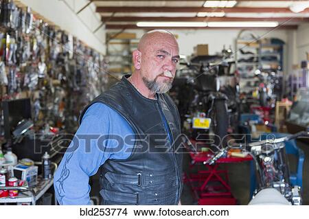 Picture - Portrait of Caucasian man repairing motorcycle. Fotosearch