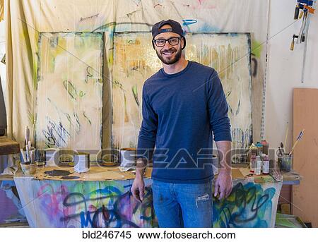 Portrait of Caucasian man standing near paintings View Large Photo Image Stock Photography - Portrait of Caucasian man standing near paintings. Fotosearch