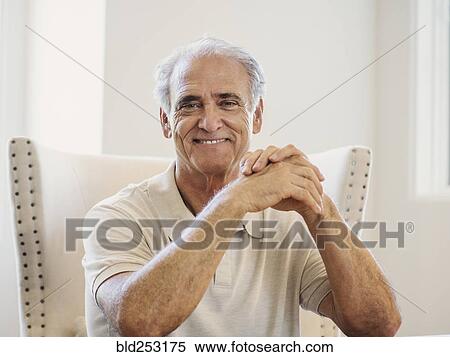 Portrait of Caucasian man with hands clasped at table View Large Photo Image Stock Photography - Portrait of Caucasian man with hands clasped at table. Fotosearch