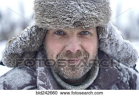 Stock Image - Portrait of Caucasian man with ice in bear in winter. Fotosearch