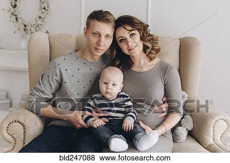 Portrait of Caucasian mother and father on love seat with baby son View Large Photo Image Stock Photo - Portrait of Caucasian mother and father on love seat with baby son. Fotosearch