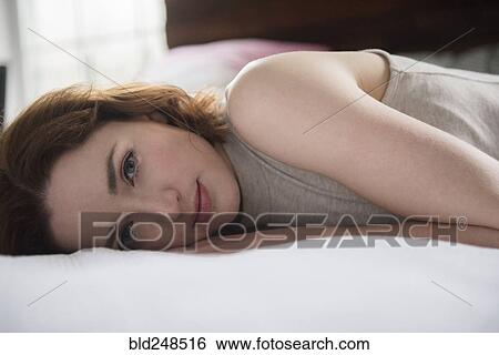 Portrait of Caucasian woman laying on bed View Large Photo Image Stock Photograph - Portrait of Caucasian woman laying on bed. Fotosearch