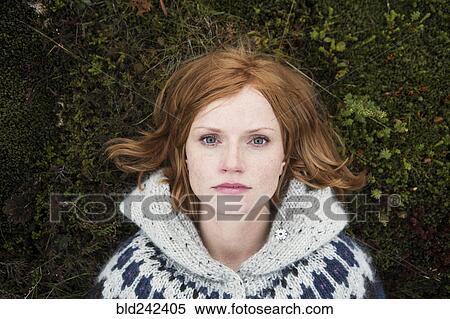 Stock Photography - Portrait of Caucasian woman laying on moss. Fotosearch