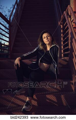 Portrait of Caucasian woman resting on metal staircase View Large Photo Image Stock Image - Portrait of Caucasian woman resting on metal staircase. Fotosearch