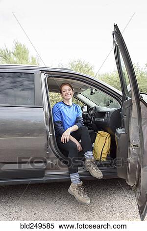 Portrait of Caucasian woman sitting in car with door open View Large Photo Image Stock Photography - Portrait of Caucasian woman sitting in car with door open. Fotosearch