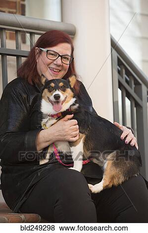 Portrait of Caucasian woman sitting on stoop holding dog View Large Photo Image Stock Photo - Portrait of Caucasian woman sitting on stoop holding dog. Fotosearch