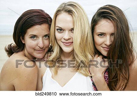 Stock Image - Portrait of confident Caucasian women on beach. Fotosearch