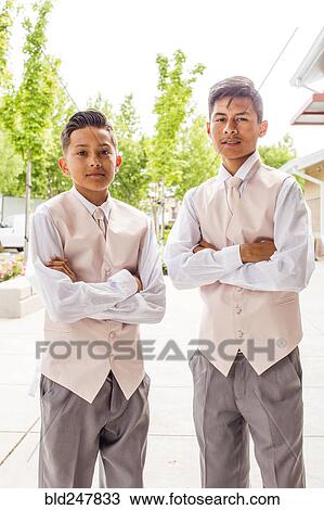 Stock Image - Portrait of confident Hispanic boys wearing suits. Fotosearch