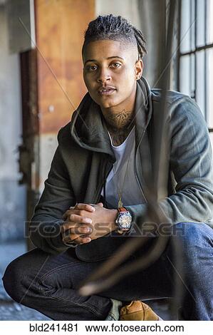 Portrait of crouching androgynous Mixed Race woman View Large Photo Image Stock Image - Portrait of crouching androgynous Mixed Race woman. Fotosearch