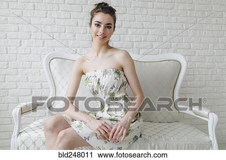 Stock Image - Portrait of glamorous Middle Eastern woman sitting on bench. Fotosearch