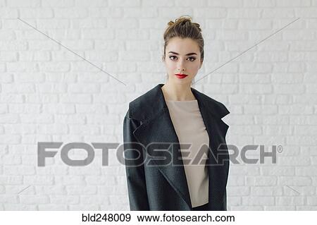 Stock Photo - Portrait of glamorous Middle Eastern woman near brick wall. Fotosearch