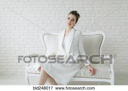 Stock Photo - Portrait of glamorous Middle Eastern woman sitting on bench. Fotosearch