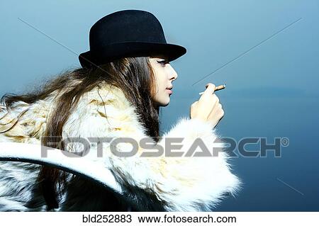 Portrait of glamorous woman wearing fur coat smoking cigarette View Large Photo Image Stock Image - Portrait of glamorous woman wearing fur coat smoking cigarette. Fotosearch