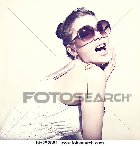 Stock Image - Portrait of glamorous woman wearing sunglasses. Fotosearch