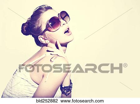 Stock Image - Portrait of glamorous woman wearing sunglasses. Fotosearch