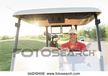 Stock Photograph - Portrait of Hispanic golfer driving golf cart. Fotosearch
