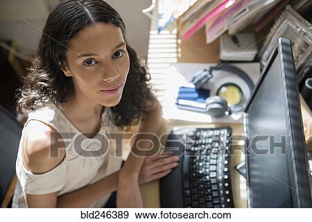 Stock Photo - Portrait of Hispanic woman using computer. Fotosearch