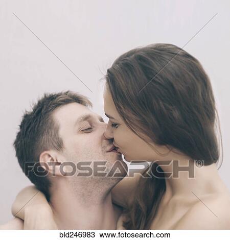 Stock Image - Portrait of kissing Caucasian couple. Fotosearch
