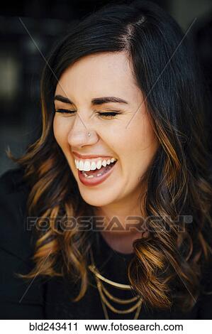 Stock Image - Portrait of laughing Mixed Race woman with pierced nose. Fotosearch