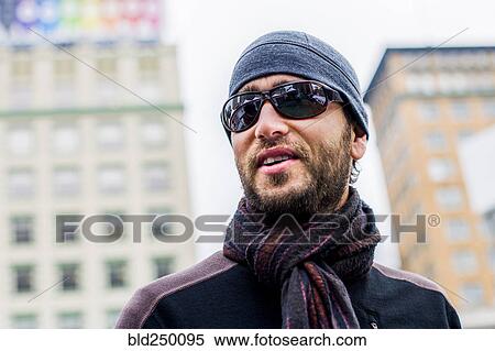 Stock Photography - Portrait of man with beard wearing hat and scarf. Fotosearch
