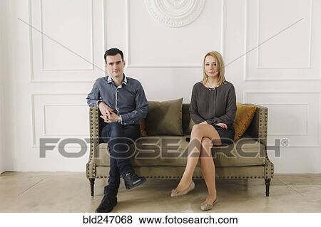 Stock Photo - Portrait of Middle Eastern couple sitting on sofa. Fotosearch