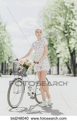 Portrait of Middle Eastern woman holding bouquet and bicycle View Large Photo Image Stock Image - Portrait of Middle Eastern woman holding bouquet and bicycle. Fotosearch
