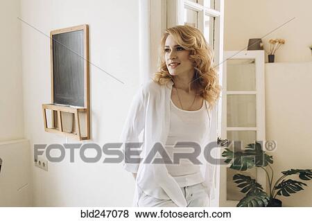 Stock Photo - Portrait of Middle Eastern woman leaning on doorway. Fotosearch