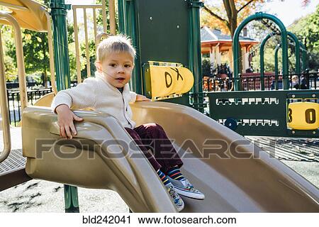 Portrait of Mixed Race boy sitting on playground slide View Large Photo Image Stock Image - Portrait of Mixed Race boy sitting on playground slide. Fotosearch