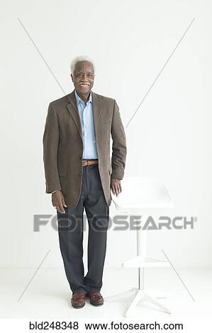 Stock Photo - Portrait of older Black man leaning on store. Fotosearch