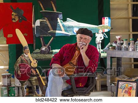 Stock Image - Portrait of older Caucasian man sitting in workshop. Fotosearch