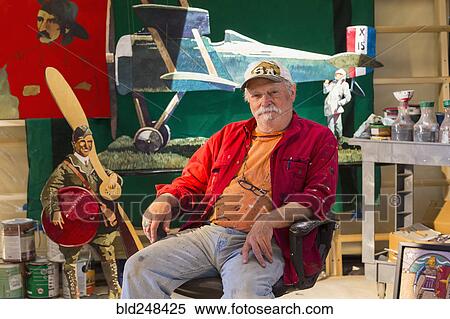 Stock Photography - Portrait of older Caucasian man sitting in workshop. Fotosearch