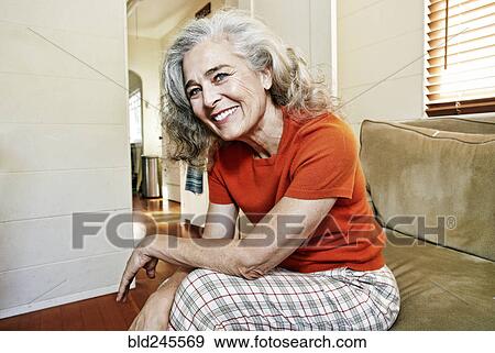 Stock Photo - Portrait of older Caucasian woman sitting on sofa. Fotosearch
