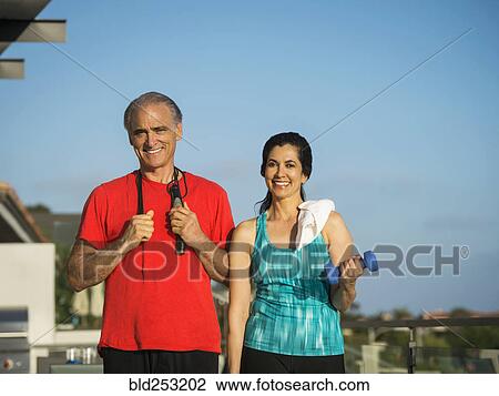 Stock Image - Portrait of older couple resting outdoors after workout. Fotosearch