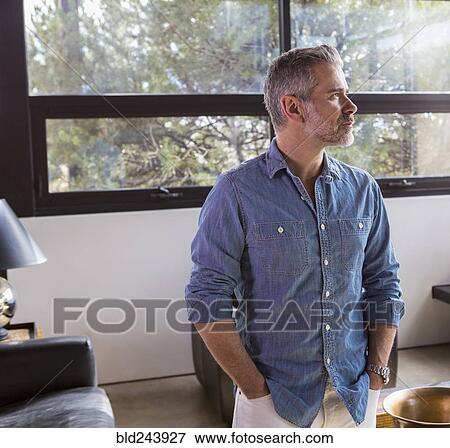 Portrait of pensive Caucasian man in livingroom View Large Photo Image Stock Photo - Portrait of pensive Caucasian man in livingroom. Fotosearch