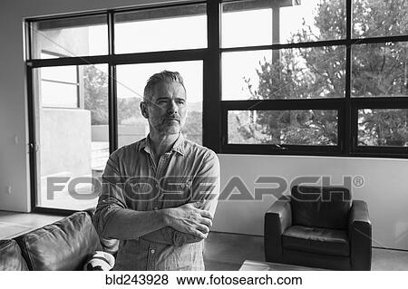 Stock Photo - Portrait of pensive Caucasian man in livingroom. Fotosearch