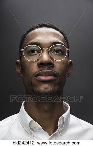 Stock Image - Portrait of serious Black man wearing eyeglasses. Fotosearch