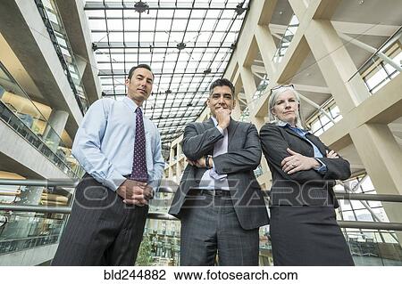 Portrait of serious business people in lobby View Large Photo Image Stock Image - Portrait of serious business people in lobby. Fotosearch