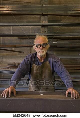 Stock Photo - Portrait of serious Caucasian blacksmith in workshop. Fotosearch